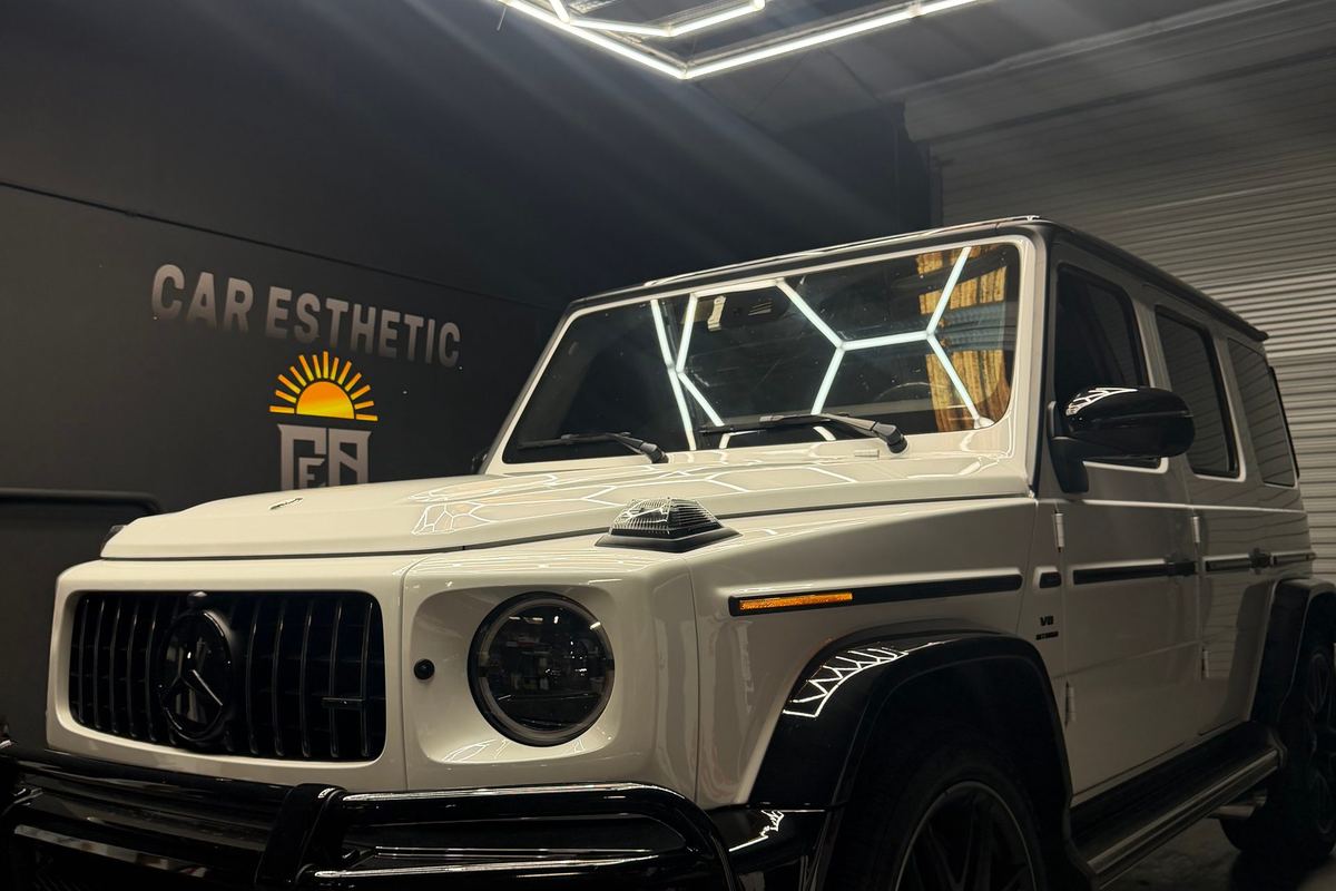 White Mercedes G-Wagon with dark window tint under hex lights at the CEA shop in Orlando